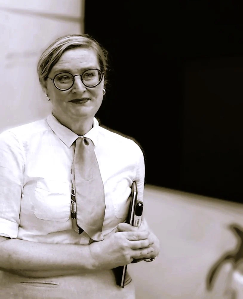 Black and white portrait photograph of Penny Maxwell, founder of Maxwell Minds, holding a notebook