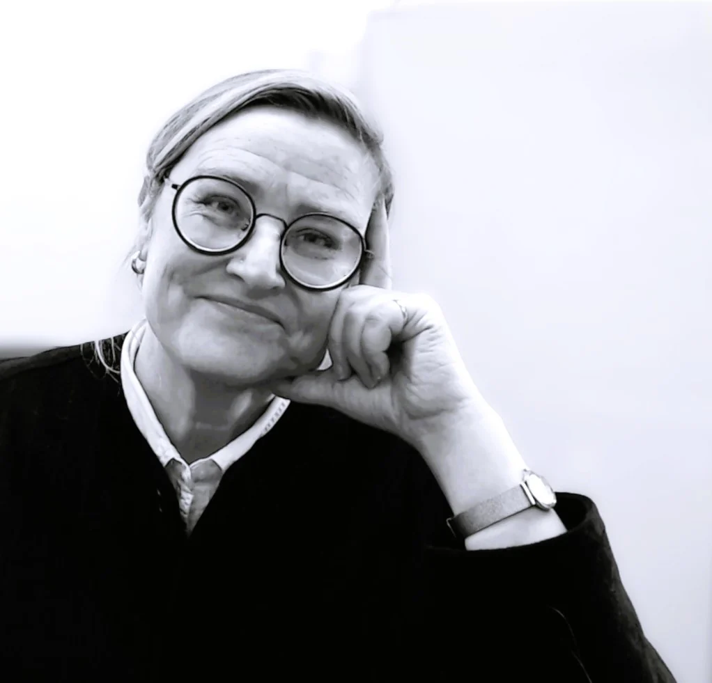 Black and white portrait photograph of Penny Maxwell, founder of Maxwell Minds, seated and smiling